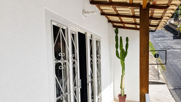 Un bâtiment blanc avec une fenêtre ornée de barreaux en métal décoratifs.