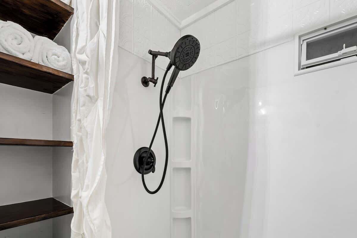 Eine Dusche mit Handbrause und fest installierter Bedienung.