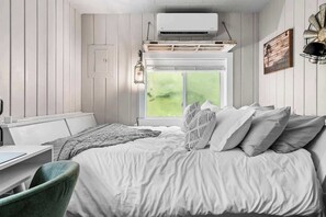 A room with a bed, a desk, and a window with a view. - Windmill Cottage | Lake Access, Pets OK + Fire Pit (Grawn)