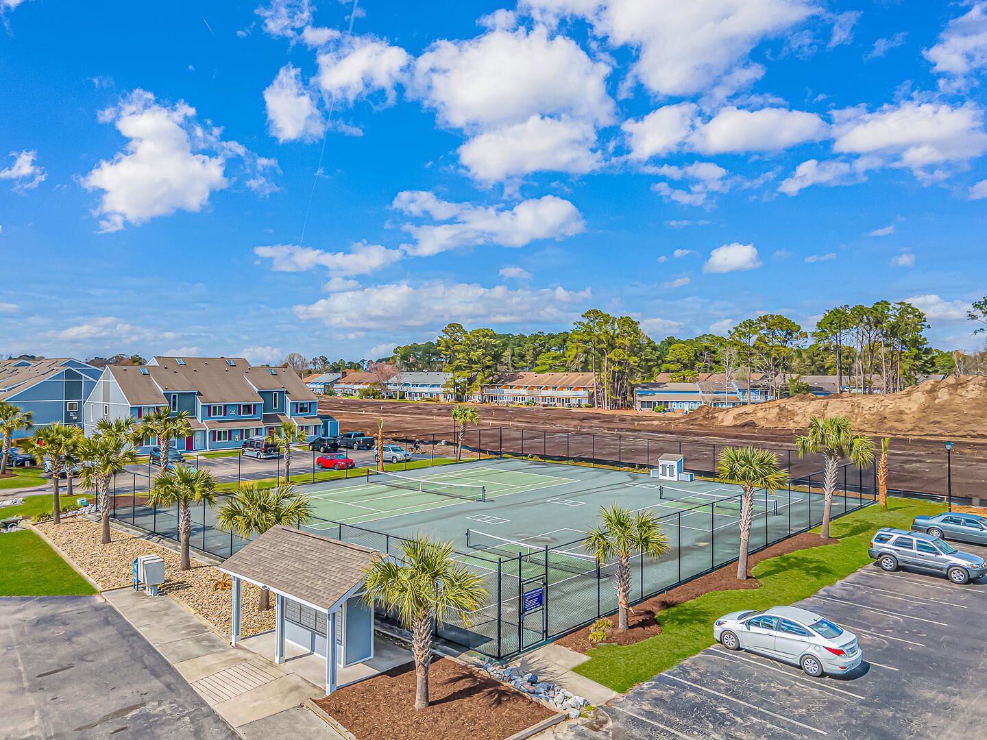 Zona residencial con casas, una cancha de tenis y un estacionamiento.