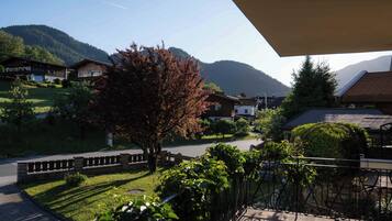 A residential area with houses, a tree, and mountains in the background.