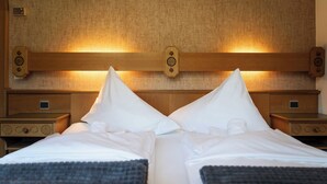 Ein Doppelbett mit weißer Bettwäsche und zwei Nachttische mit Holzoptik.