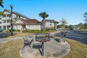 A residential area with a paved patio, benches, a grill, and a mailbox. - Barefoot Cypress 523- 2 Bedroom Condo (North Myrtle Beach)