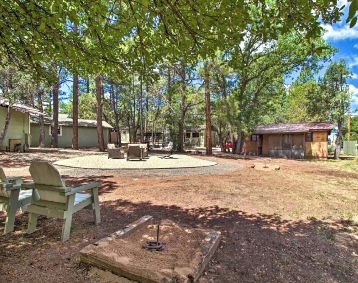 A backyard with a circular seating area, a fire pit, and a small shed.