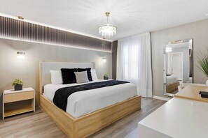 Une chambre moderne avec un grand lit, des tables de chevet, un miroir et un lustre.
