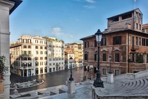 A historic urban street with classical architecture, a canal, and a fountain. - Fellini Design Apartment (Roma)