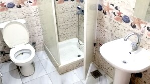 A bathroom with a toilet, a shower, and a sink. - New Radwan Hotel Luxor railway (Luxor Governorate)