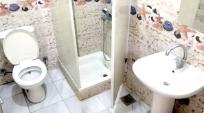 A bathroom with a toilet, a shower, and a sink. - New Radwan Hotel Luxor railway (Luxor Governorate)