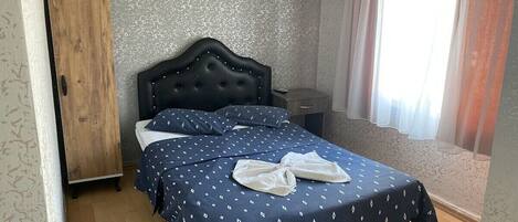 Une chambre à coucher avec un lit, une armoire et une fenêtre avec des rideaux.