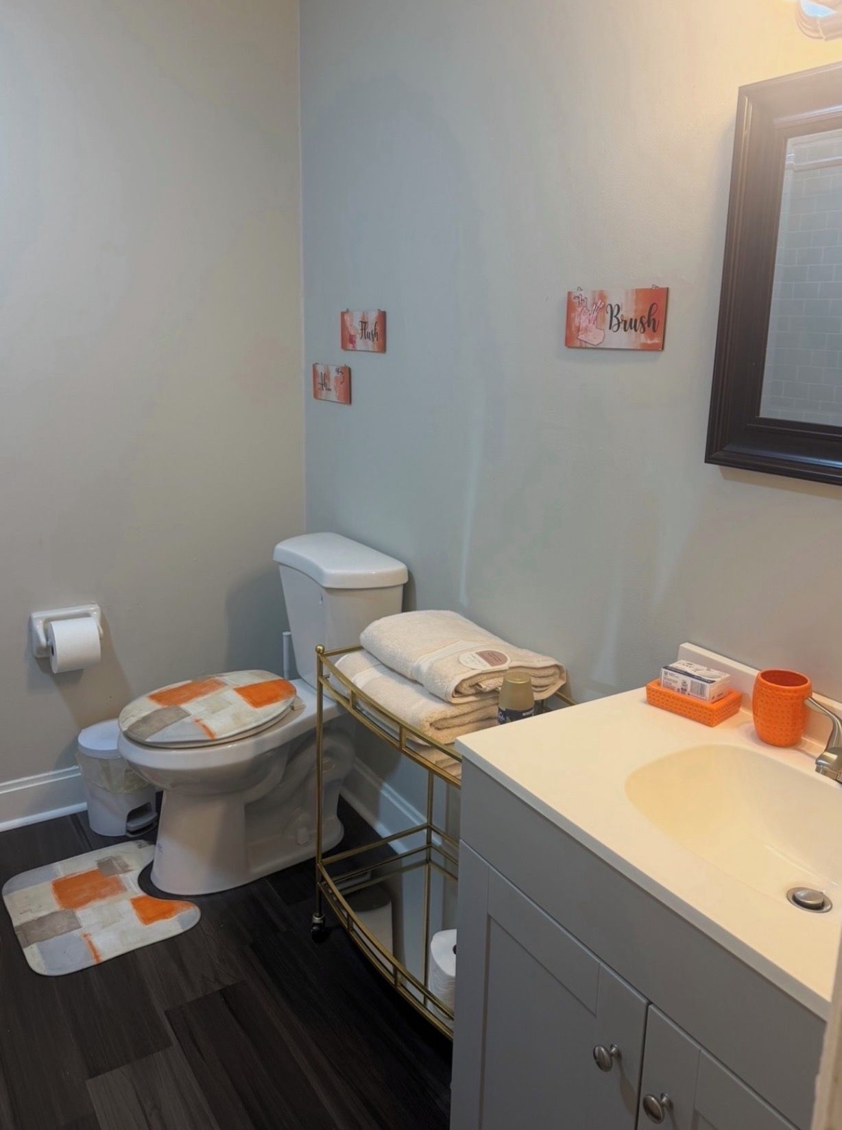 Een badkamer met toilet, bidet, wastafel en een handdoekhouder.