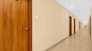 A hotel corridor with wooden doors, numbered 218, and a tiled floor.