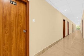 Pasillo de hotel con puertas de madera, número 218, y suelo de baldosas.