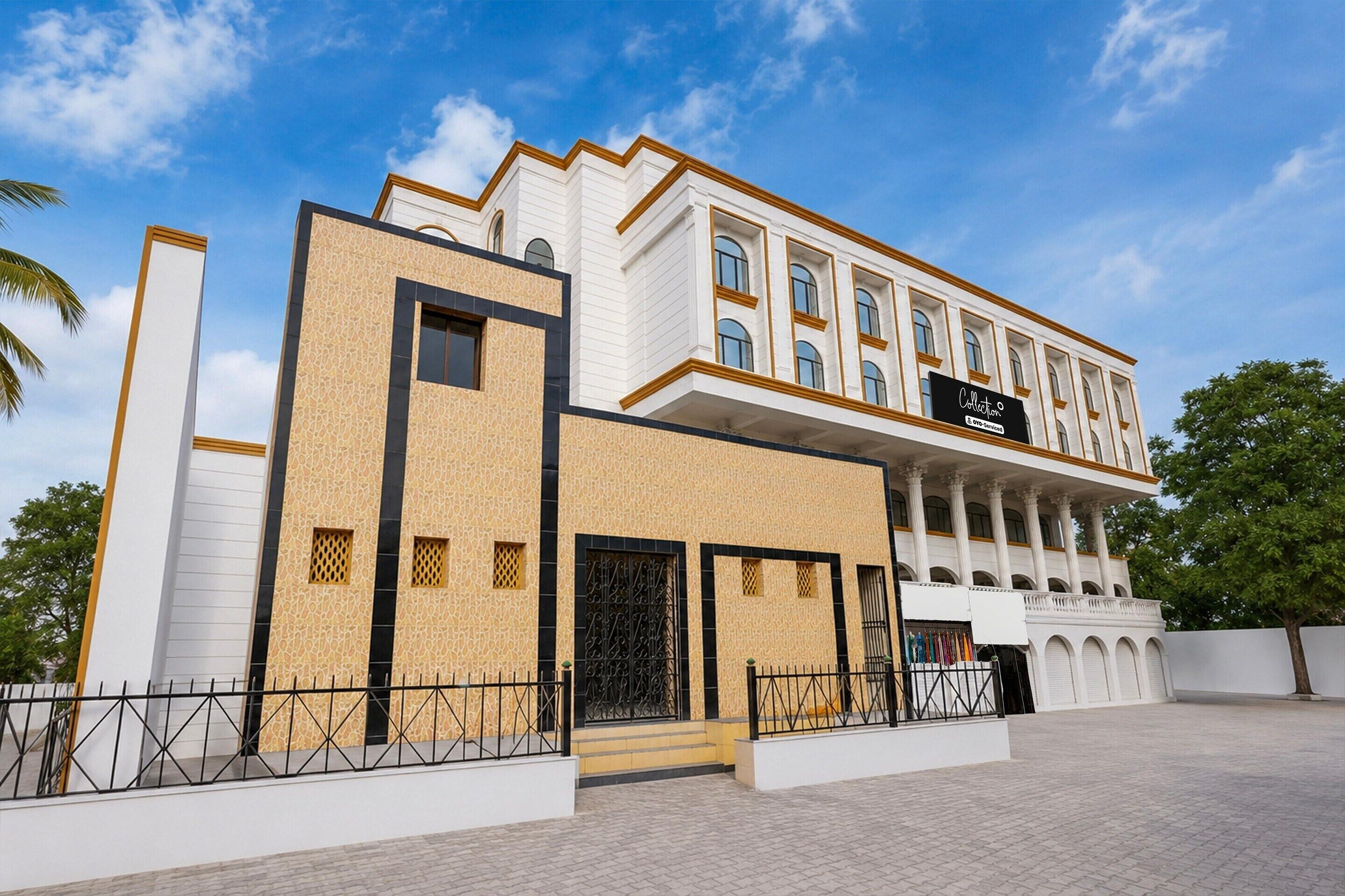 A modern building with a white facade, large windows, and a sign indicating it is a collection.