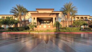 A hotel entrance with a large reflective floor, palm trees, and a building with columns and a flat roof. - Worldmark Boulevard 2-bedroom resort in beautiful Las Vegas (Las Vegas)