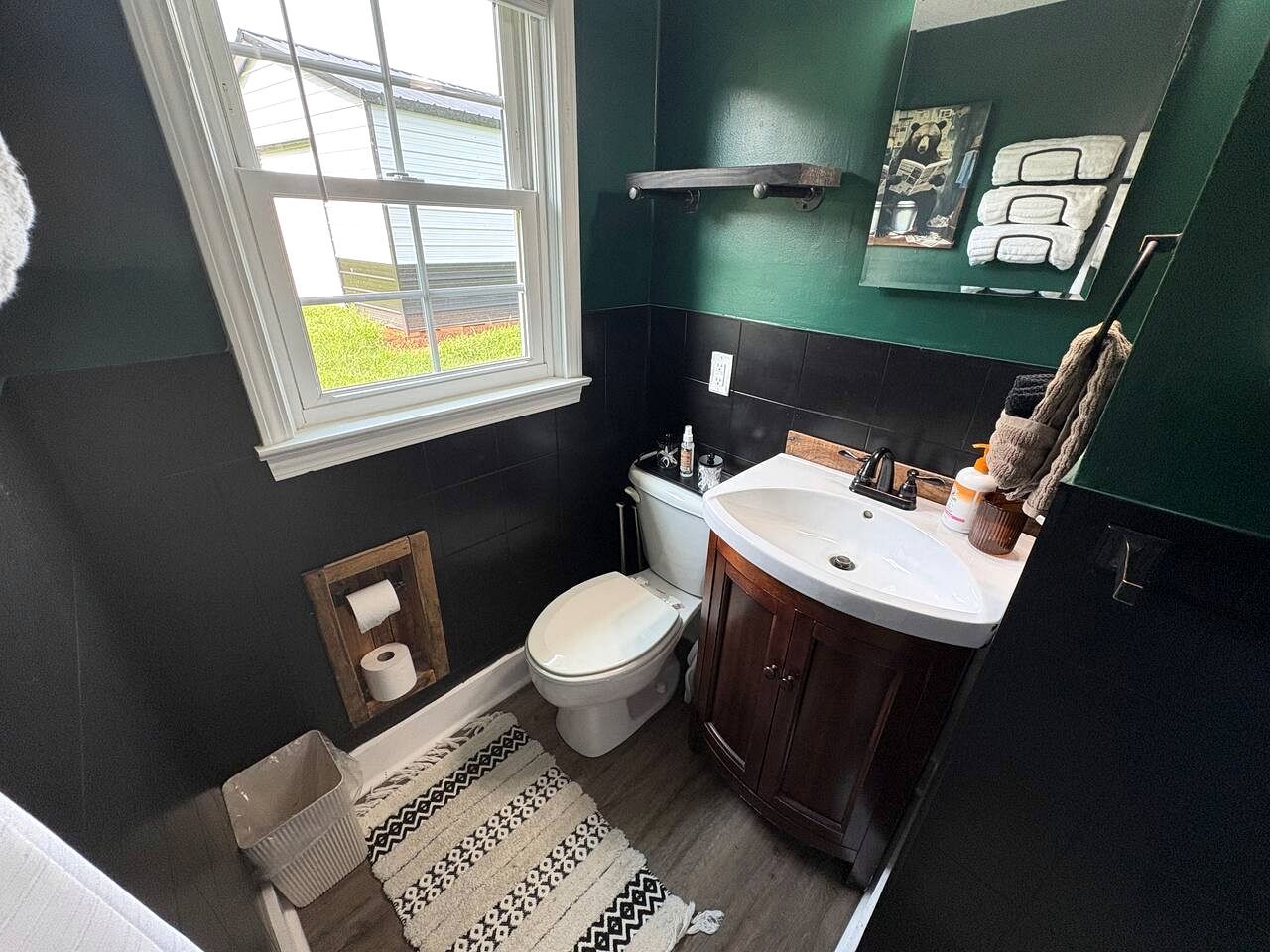 Een badkamer met toilet, wastafel en raam.