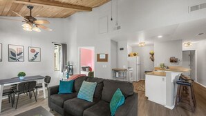 A modern living room with a sofa, dining table, and kitchen area. - Lakeside Vibes | 2BR, Walk to Boulder Bay, Pool (Big Bear Lake)