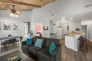 A modern living room with a sofa, dining table, and kitchen area. - Lakeside Vibes | 2BR, Walk to Boulder Bay, Pool (Big Bear Lake)