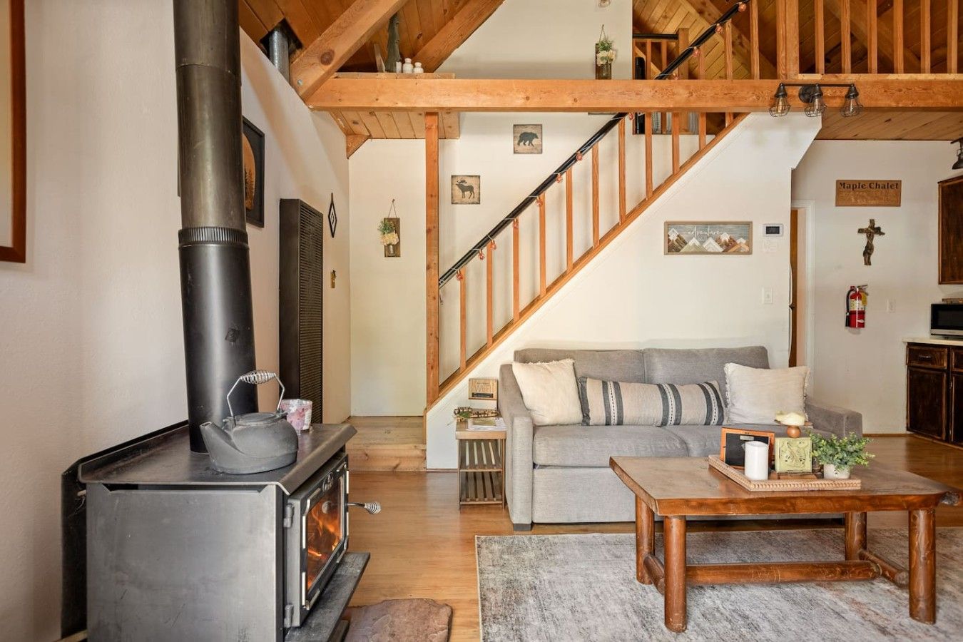 A cozy living room with a fireplace, a sofa, a coffee table, and a staircase.