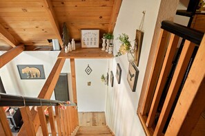 Eine Holztreppe mit einem Schild, das 'LIVING OUR LAKE LIFE' zeigt, und gerahmten Bildern an den Wänden.