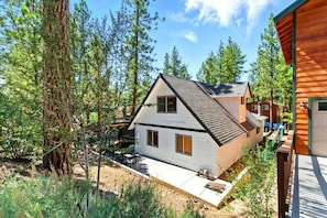 A two-story house with a sloped roof, surrounded by tall trees and a clear sky. - Big Bear Cabana Near Lake W/ Hot Tub, Shuffleboard (Big Bear Lake)