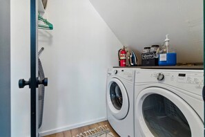 A laundry area with two washing machines, a fire extinguisher, and laundry detergent bottles. - Big Bear Cabana Near Lake W/ Hot Tub, Shuffleboard (Big Bear Lake)