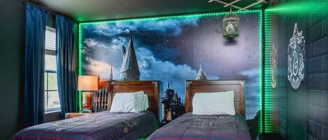 A bedroom with two beds, a night sky mural, and a green neon light strip.