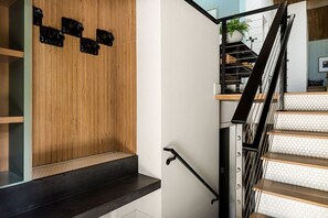 Una escalera con barandilla de metal negro y escalones de madera.