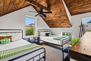 A bedroom with two beds, a ceiling fan, and large windows. - Modern Tiny Home! Walk to Parkway*Hot Tub*Sleeps 6 (Pigeon Forge)