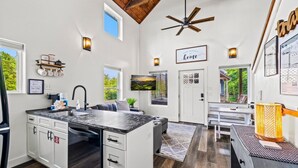 Una cucina moderna con un'isola grande, elettrodomestici integrati e una ventola a soffitto.
