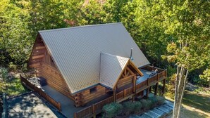 A log cabin with a metal roof, a deck, and a porch. - Peaceful 3BR*MTN Views*Hot Tub*Pool Table*Fire Pit (Sevierville)