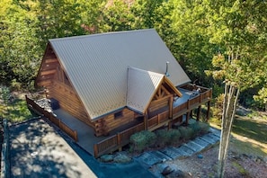 Eine Blockhütte mit Metalldach, einer Veranda und einer Terrasse.