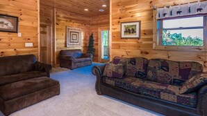 A cozy cabin interior with a brown leather sofa, a patterned couch, and a wooden ceiling. - Peaceful 3BR*MTN Views*Hot Tub*Pool Table*Fire Pit (Sevierville)