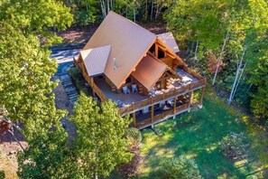 A cabin with a large deck, surrounded by trees. - Peaceful 3BR*MTN Views*Hot Tub*Pool Table*Fire Pit (Sevierville)