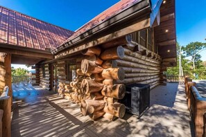 Eine Blockhütte mit einer Holzterrasse und einem Metalldach.