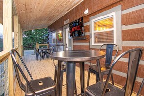 Ein Außenbereich mit Metallstühlen und einem runden Tisch, einer Holzterrasse und einer Ziegelwand mit einem Netflix-Schild.