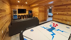 A wooden interior with a pool table, bar area, and a television. - 5BR Pool Cabin w/MTN Views! Hot Tub*Games*Zipline! (Sevierville)