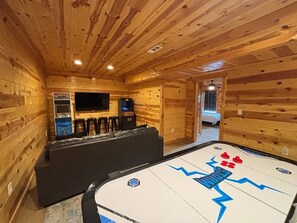 A wooden interior with a pool table, bar area, and a television. - 5BR Pool Cabin w/MTN Views! Hot Tub*Games*Zipline! (Sevierville)