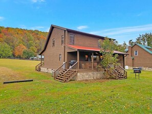 Ein zweistöckiges Holzhaus mit einer Veranda und einer Treppe.