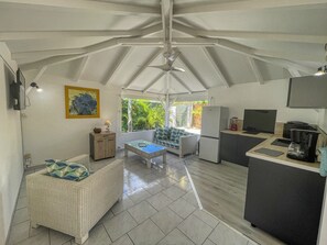 A compact kitchen with a dining area, a refrigerator, a coffee maker, and a television. - Charming villa with pool - 2 guests (Saint-François)