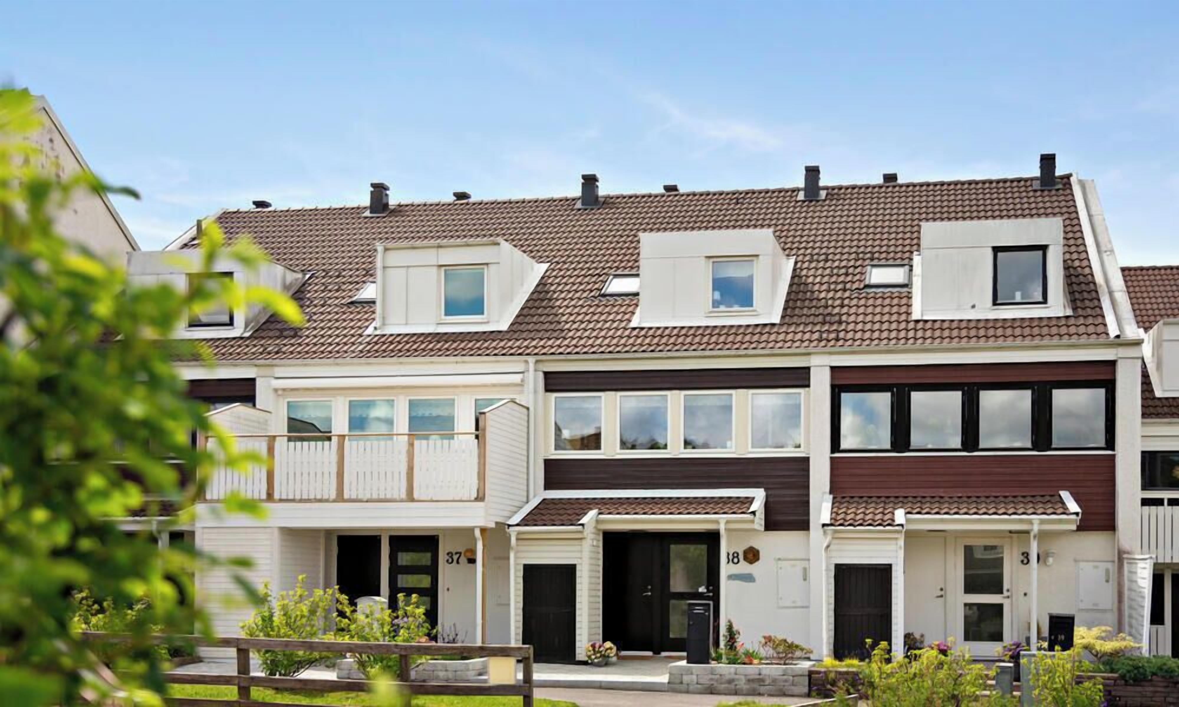 A two-story residential building with a balcony, a garage, and a front door.