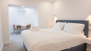 Ein modernes Schlafzimmer mit einem großen Bett, einem Schreibtisch und zwei Stühlen.