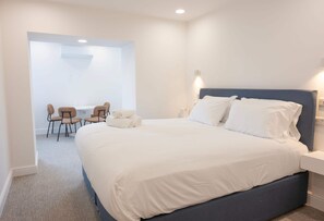 Ein modernes Schlafzimmer mit einem großen Bett, einem Schreibtisch und zwei Stühlen.