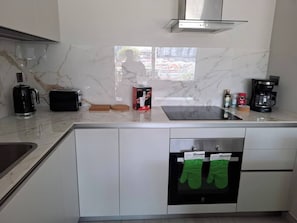 Una cuina moderna amb rentaplats integrat, cafetera i torradora.