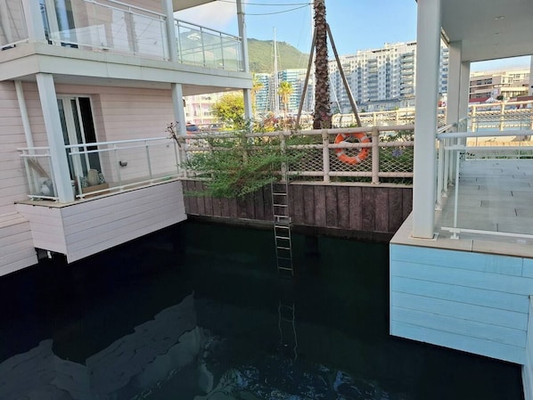 A multi-level boat with a water feature, a ladder, and a view of the surrounding area.