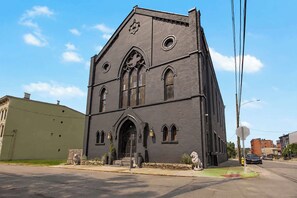 Uma igreja grande e escura, com uma torre imponente e janelas em arco.