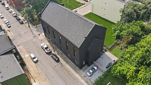 Ein Gebäude mit flachem Dach, Parkplatz und einer grünen Rasenfläche.