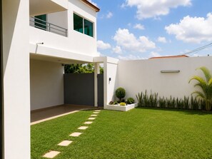 A modern two-story house with a flat roof, a covered patio, and a well-maintained lawn with stepping stones. - Beautiful 5 bedrooms Villa in charming Abidjan (Abidjan)