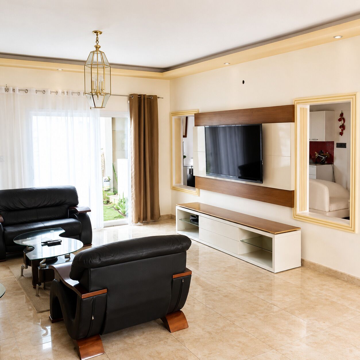 A modern living room with a flat-screen TV, leather sofa, and a coffee table.