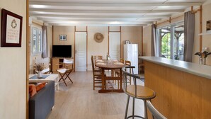 Un espace de vie compact comprenant un coin repas, une cuisine et un coin salon.