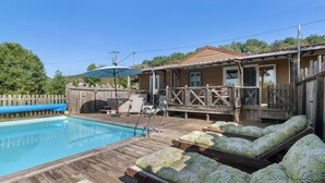 Un espace piscine avec des chaises longues et une terrasse en bois.